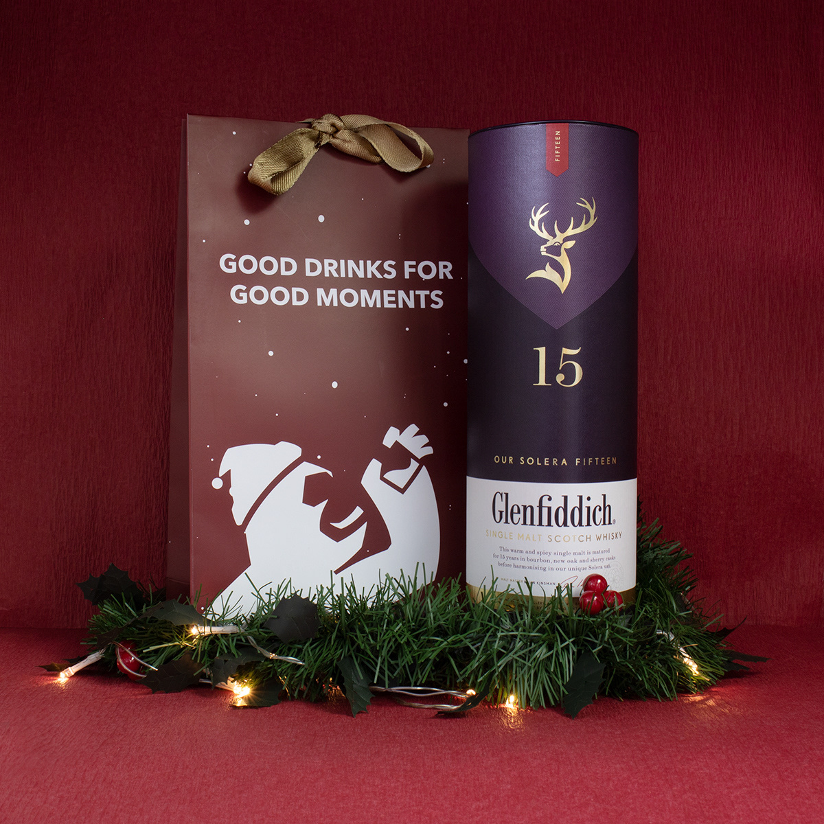 Christmas edition carrier bag with a Glenfiddich 15 tube on pine and fairy lights